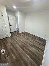 unfurnished bedroom with dark wood-type flooring