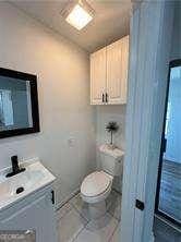 bathroom featuring tile patterned flooring, vanity, and toilet