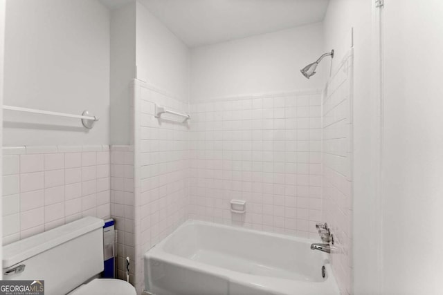 bathroom with toilet, tile walls, and shower / bathing tub combination