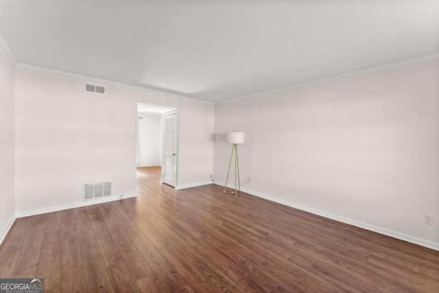 spare room featuring crown molding and dark hardwood / wood-style floors