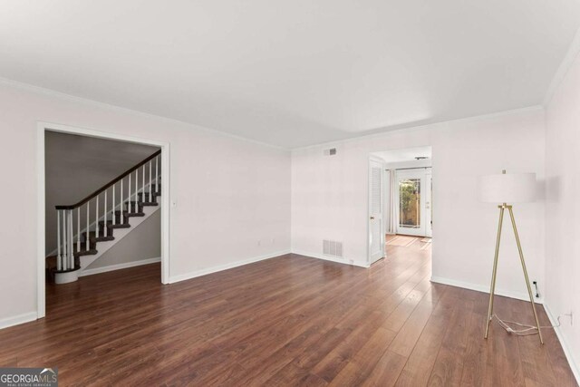 empty room with dark hardwood / wood-style flooring and ornamental molding