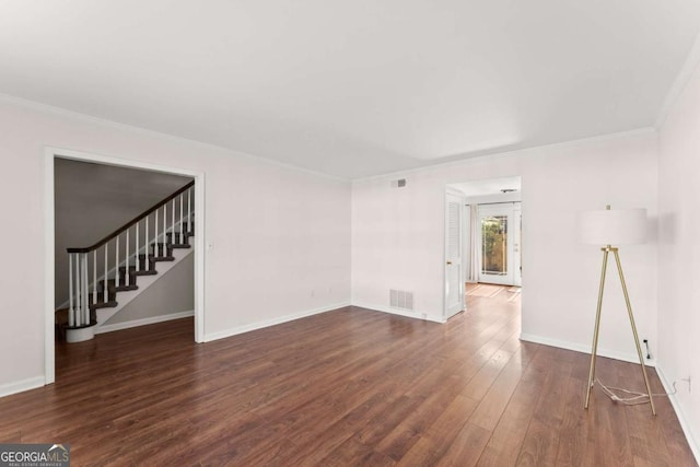 spare room with ornamental molding and dark hardwood / wood-style floors