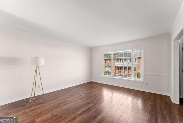 spare room featuring dark hardwood / wood-style flooring and ornamental molding