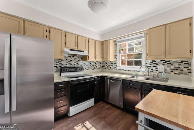 kitchen featuring sink, crown molding, dark wood-type flooring, stainless steel appliances, and decorative backsplash