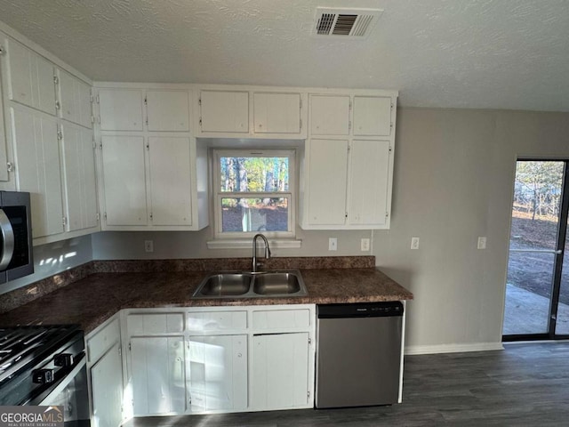 kitchen featuring a textured ceiling, white cabinets, a wealth of natural light, stainless steel appliances, and sink