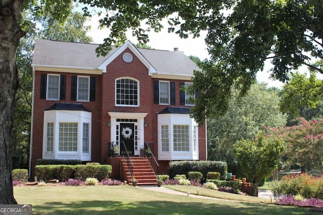 colonial house featuring a front lawn