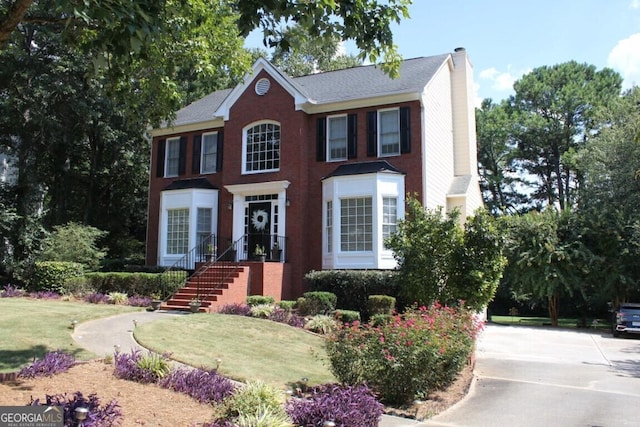 colonial inspired home featuring a front yard