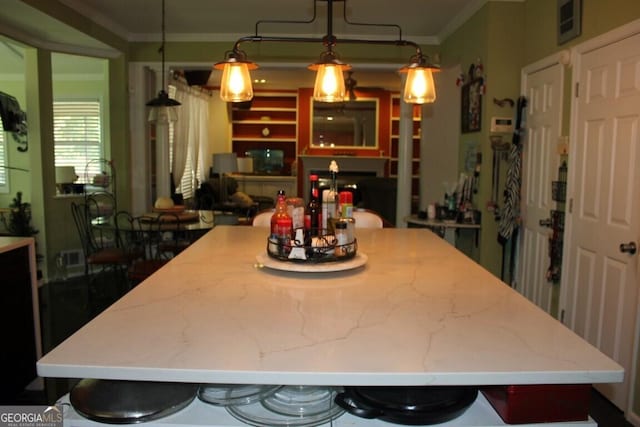 kitchen featuring a kitchen bar, pendant lighting, and ornamental molding