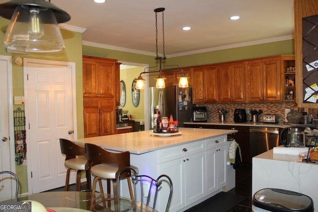 kitchen with a center island, white cabinets, crown molding, tasteful backsplash, and stainless steel appliances