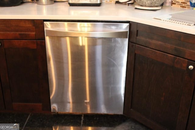 kitchen with stainless steel dishwasher, dark brown cabinetry, and backsplash