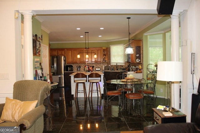 dining room with decorative columns and ornamental molding