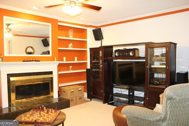 living room featuring ceiling fan, crown molding, and a high end fireplace