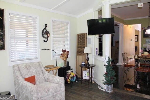 sitting room featuring dark wood-type flooring, decorative columns, and ornamental molding