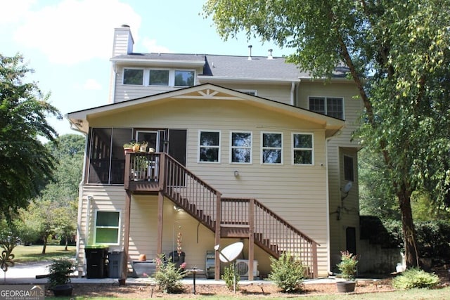 rear view of house featuring a sunroom