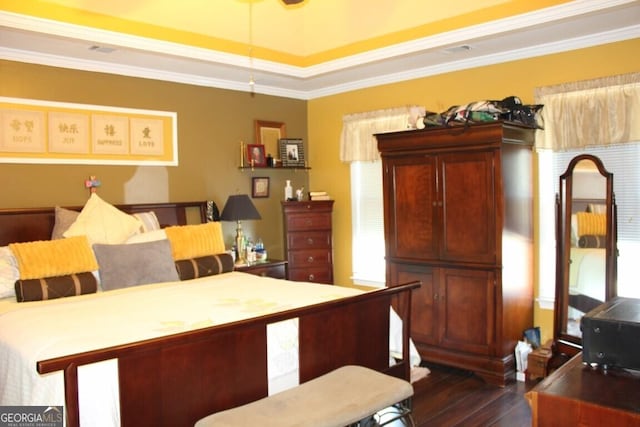 bedroom with dark hardwood / wood-style flooring, a raised ceiling, and crown molding