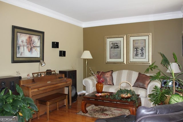 sitting room with hardwood / wood-style flooring and crown molding