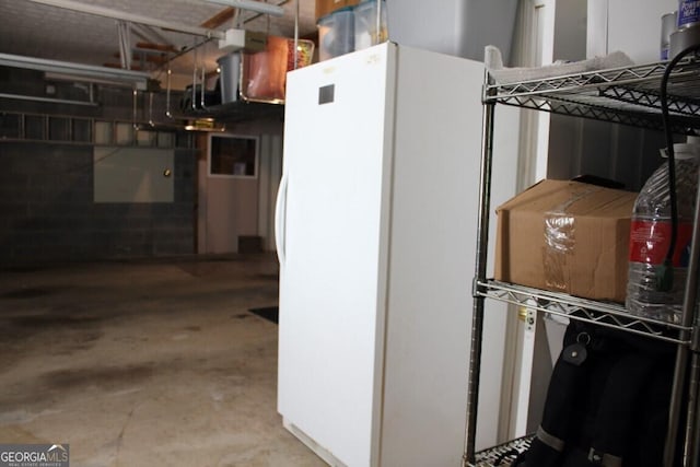 kitchen with concrete floors and white refrigerator