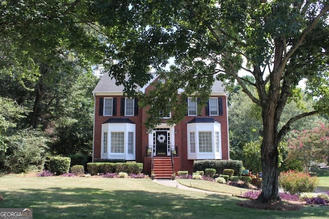 colonial house featuring a front lawn