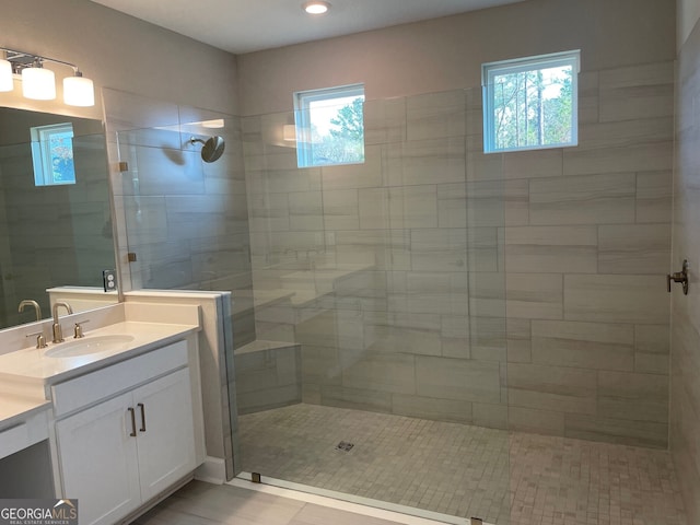 bathroom featuring a walk in shower and vanity