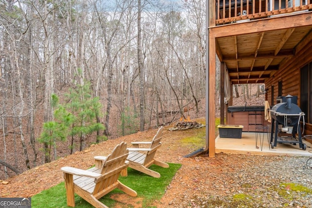 view of yard with a patio area, a wooden deck, and a hot tub