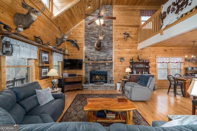 living room with ceiling fan with notable chandelier, light hardwood / wood-style flooring, high vaulted ceiling, and wooden ceiling