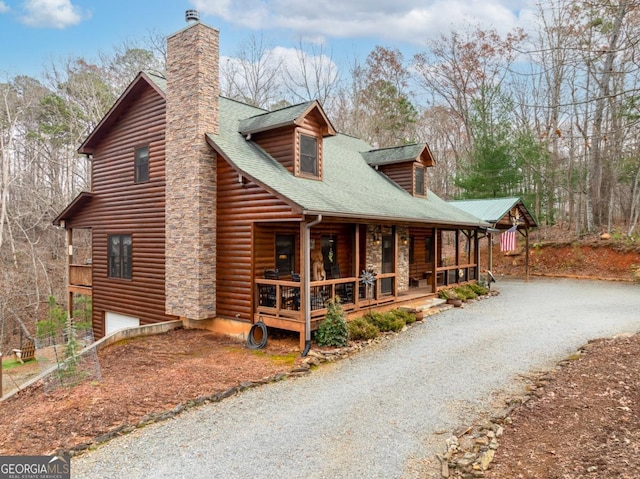 view of side of property featuring covered porch and a garage