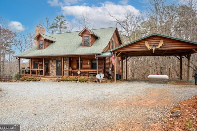 log cabin featuring a porch and a carport