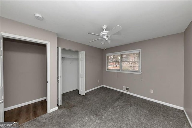 unfurnished bedroom featuring ceiling fan, a closet, and dark colored carpet