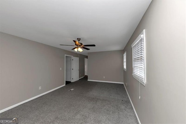 unfurnished bedroom with dark carpet and ceiling fan