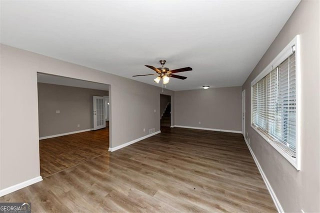 empty room with dark hardwood / wood-style flooring and ceiling fan