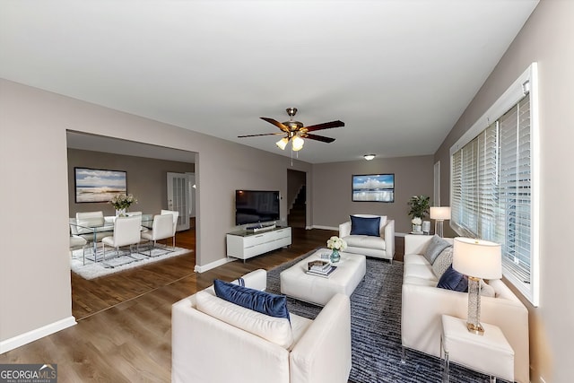 living room with ceiling fan and dark hardwood / wood-style flooring