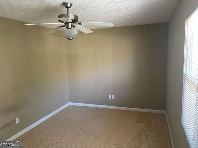 carpeted empty room with ceiling fan and a textured ceiling