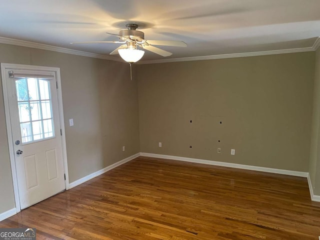 spare room featuring dark hardwood / wood-style floors, ceiling fan, and crown molding