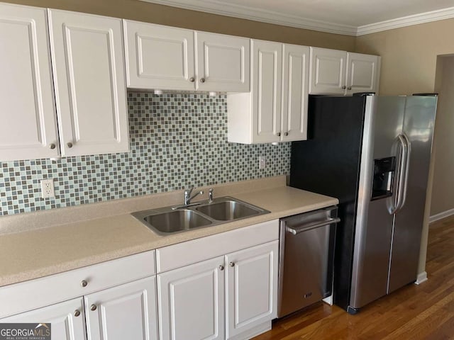 kitchen featuring sink, backsplash, appliances with stainless steel finishes, white cabinets, and ornamental molding