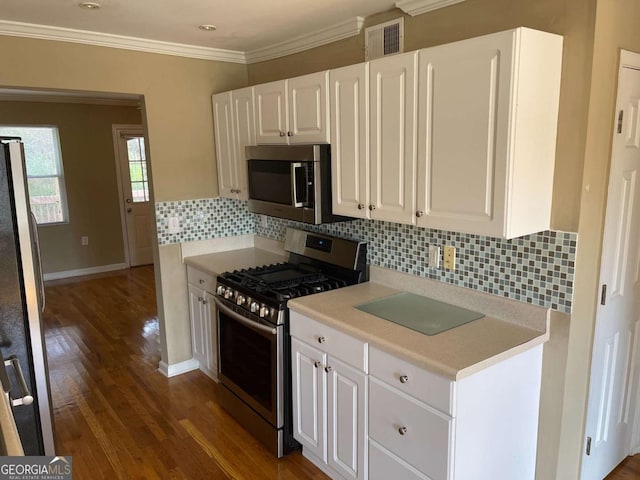 kitchen with tasteful backsplash, white cabinets, stainless steel appliances, and hardwood / wood-style flooring