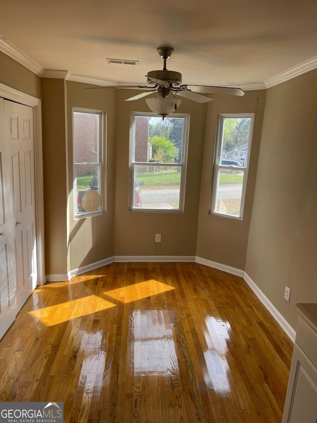 unfurnished room with a wealth of natural light, crown molding, ceiling fan, and light hardwood / wood-style floors