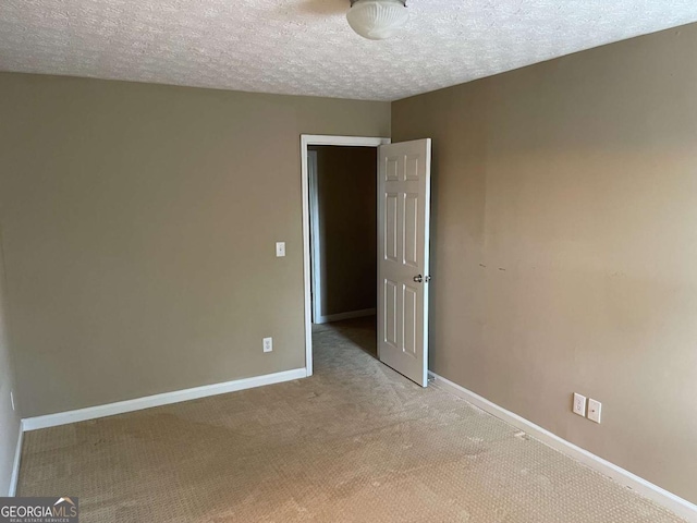 unfurnished bedroom featuring a textured ceiling and light carpet