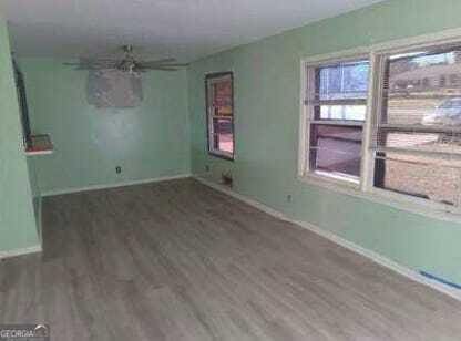 empty room with dark hardwood / wood-style flooring and ceiling fan