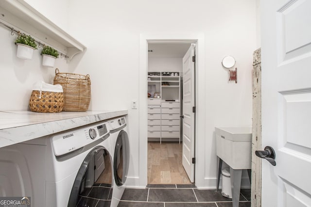 clothes washing area featuring washer and clothes dryer and dark tile patterned flooring