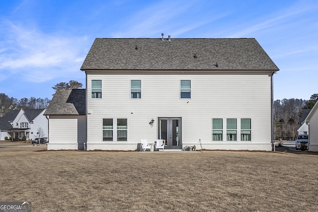 back of house with french doors and a lawn