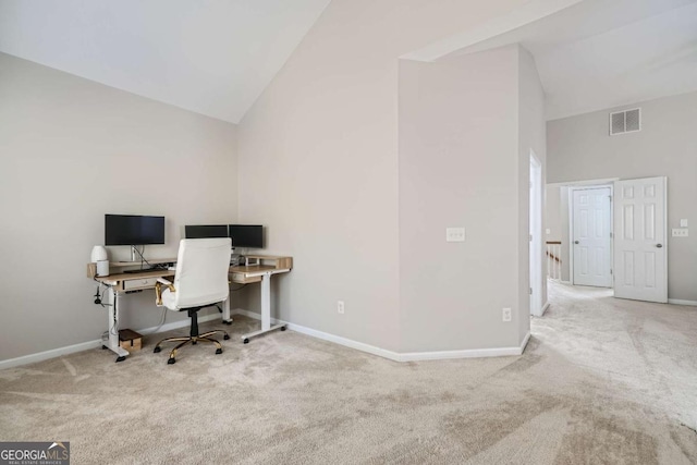 office space featuring light colored carpet and high vaulted ceiling