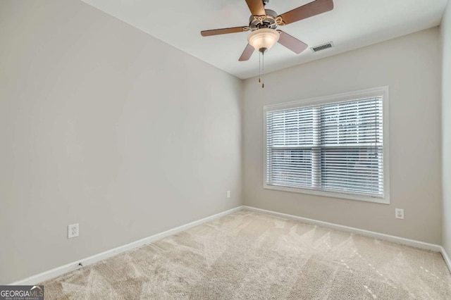 empty room with ceiling fan and light carpet