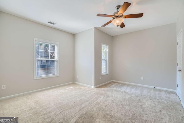 spare room with ceiling fan and light carpet