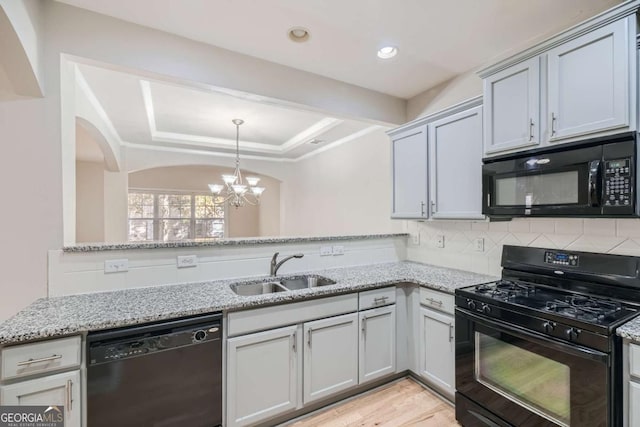 kitchen with sink, tasteful backsplash, light stone counters, and black appliances