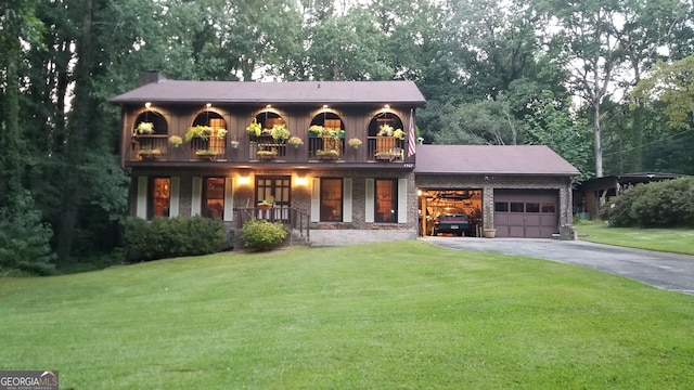 view of front of home with a garage, a balcony, and a front lawn