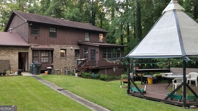 back of house with a gazebo and a lawn