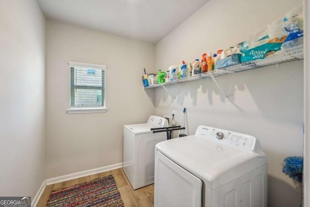 clothes washing area with light hardwood / wood-style floors and separate washer and dryer