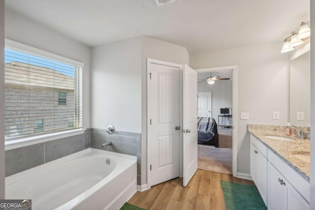 bathroom featuring hardwood / wood-style floors, vanity, a bathtub, and a wealth of natural light