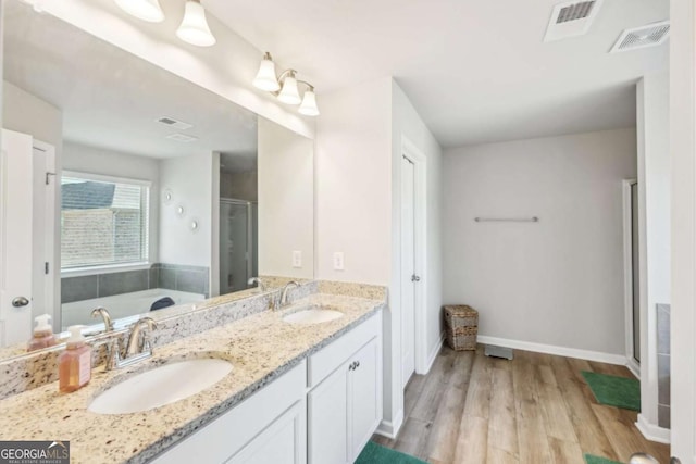 bathroom with vanity, wood-type flooring, and plus walk in shower