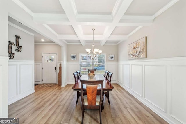 dining area featuring coffered ceiling, beamed ceiling, a chandelier, light wood-type flooring, and ornamental molding